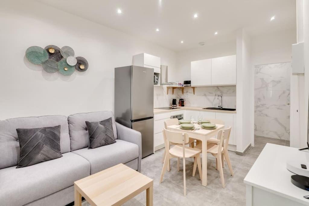 un salon avec un canapé et une table et une cuisine dans l'établissement Super T2 au Vieux Port Climatisé, à Marseille