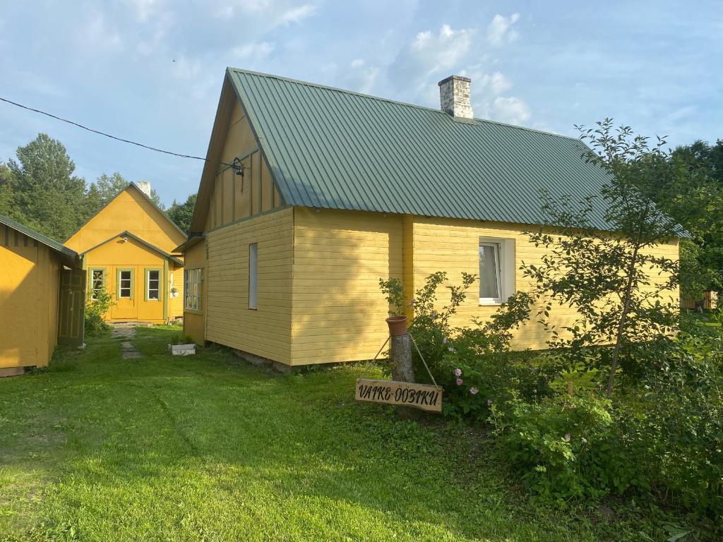 une maison jaune avec un panneau devant elle dans l'établissement Ööpiku majutus saunaga, 