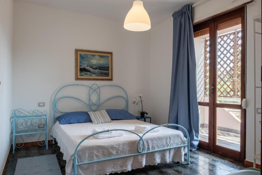 um quarto com uma cama azul e uma janela em [FREE Parking] Relax&Comfort a 5 minuti dalla Spiaggia em Santa Luria