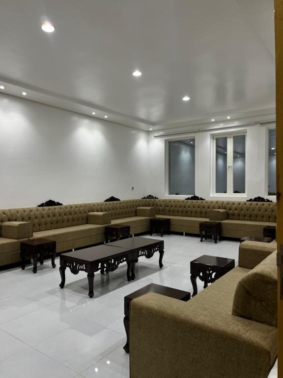 a large waiting room with couches and tables in it at استراحة الورود in Tanomah