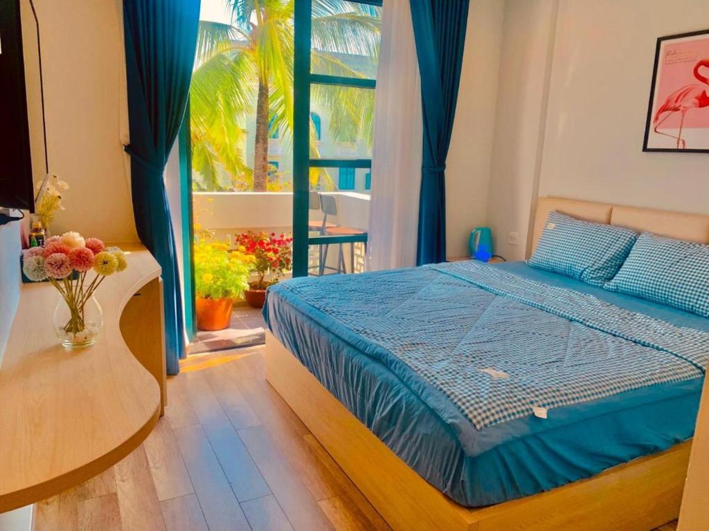 1 dormitorio con cama, mesa y ventana en Minh Phu Quoc lodge beach swimming pool, en Phu Quoc