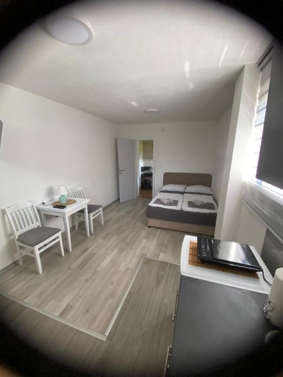 a bedroom with a bed and a desk and a table at Apartman BANJA in Višegrad