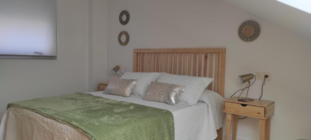 ein Schlafzimmer mit einem Bett mit einer grünen Decke in der Unterkunft Amaral Xunqueiras in Pobra do Caramiñal