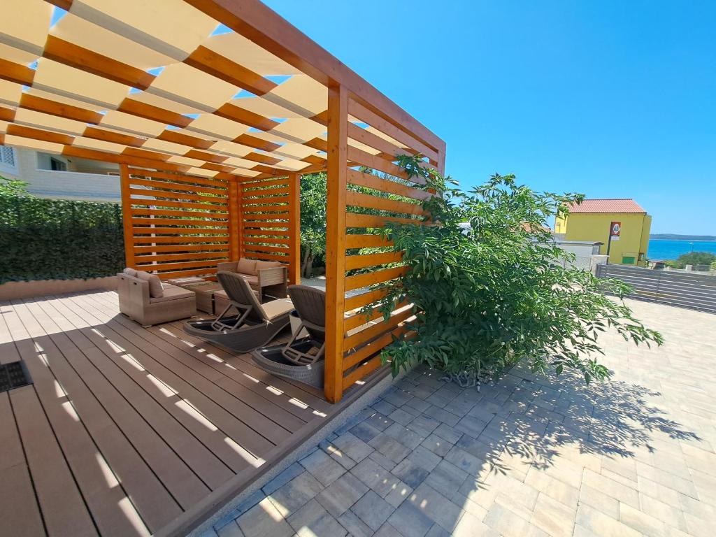 a wooden deck with a wooden pergola at Holiday house SeaDream - 50 meters from the sea in Brodarica