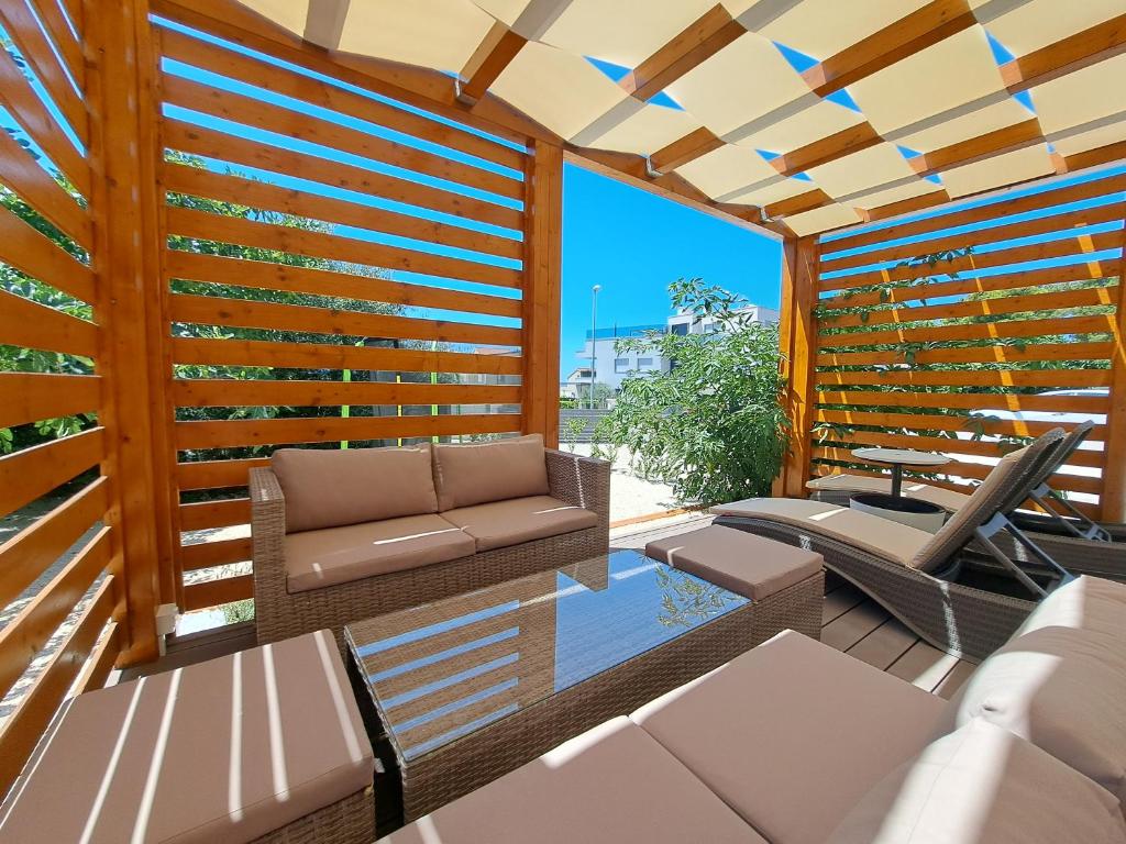 a patio with a wooden fence and a couch at Holiday house SeaDream - 50 meters from the sea in Brodarica