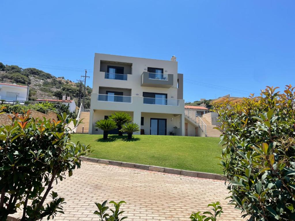 a large white building with a lawn in front of it at PENEMA VILLA in Hersonissos
