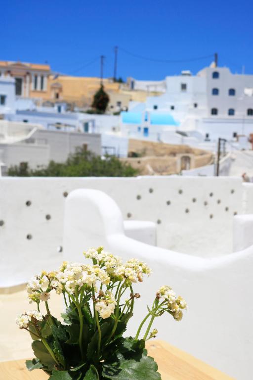 un vaso di fiori bianchi seduto su un tavolo di Stoa Cave Villas a Mesariá