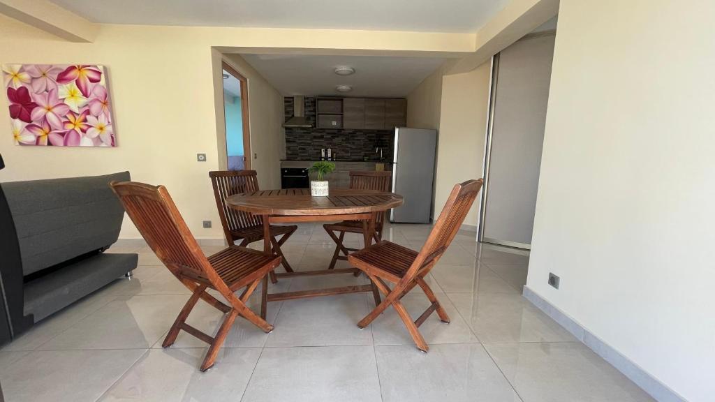 een keuken en eetkamer met een tafel en stoelen bij Auae hills lodge in Faaa