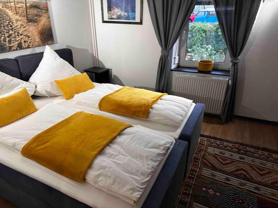 ein Schlafzimmer mit einem großen Bett mit gelben Decken in der Unterkunft Amina’s Auberge nähe Saarbrücken in Alsting