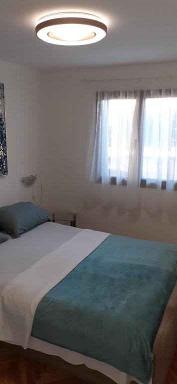 a bedroom with a large bed and a large window at Gala in Punat