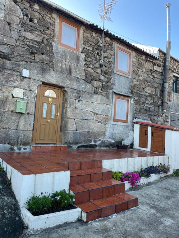 a stone building with a brown door and stairs at Casa Malvina in A Coruña