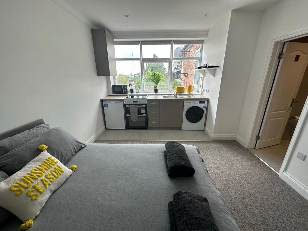 a living room with a couch and a kitchen at Sunny Modern, 1 Bed Flat, 15 Mins Away From Central London in Hendon