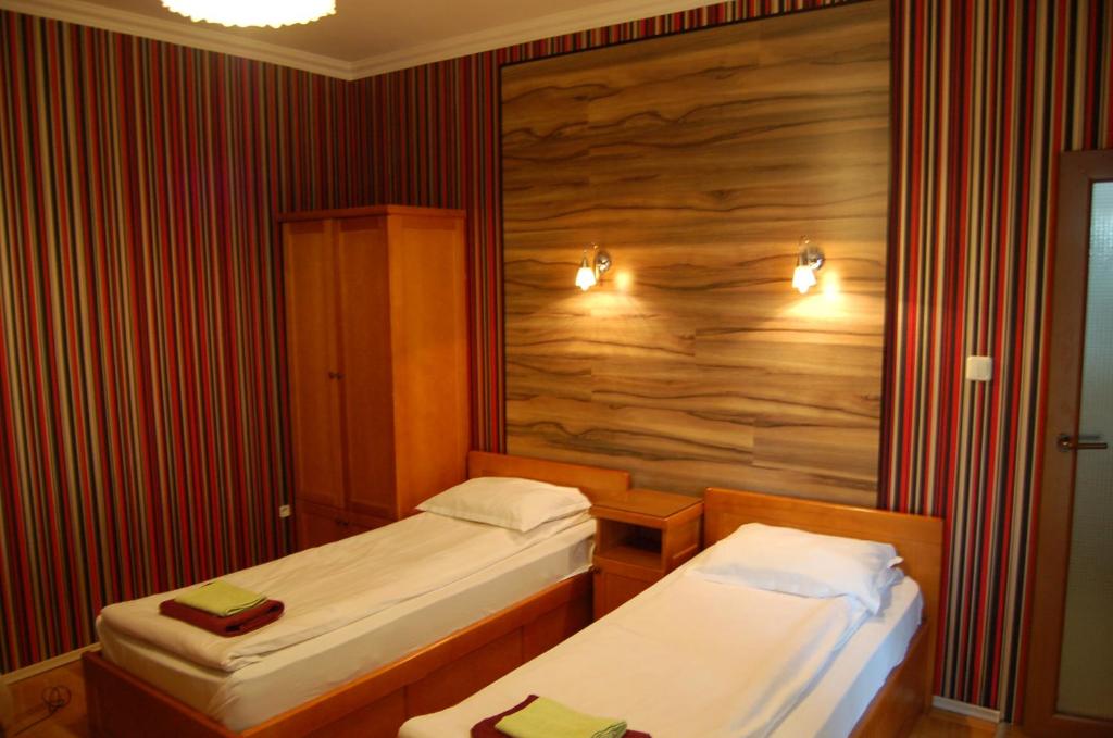 a room with two beds and a wooden wall at Kniaz Boris Hotel in Sofia