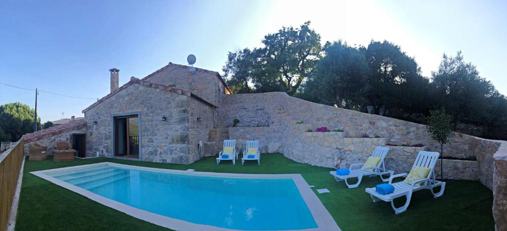 a yard with a pool and chairs and a house at Taliscas Stone Charm in Coimbra