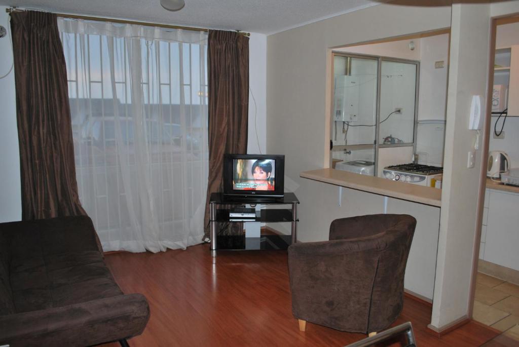 ein Wohnzimmer mit einem TV und 2 Stühlen in der Unterkunft Apartamento Don Rodolfo in Antofagasta