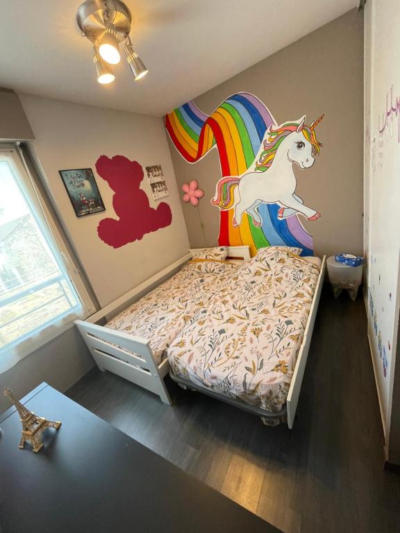 a bedroom with a bed with a unicorn on the wall at F4 lumineux proche du stade de France in Saint-Denis