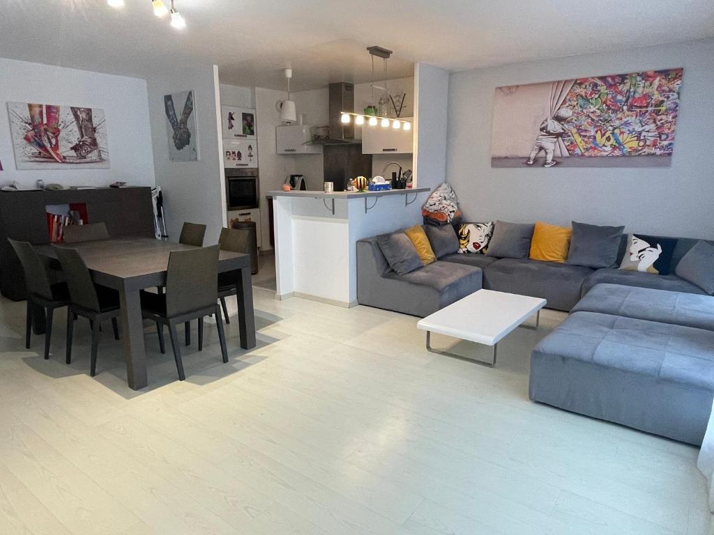 a living room and kitchen with a couch and a table at F4 lumineux proche du stade de France in Saint-Denis