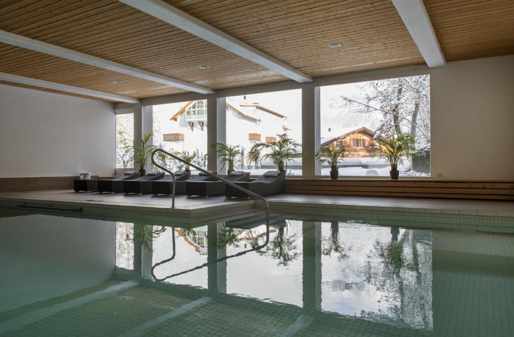 una piscina con vista su una casa di Hotel des Alpes a Flims