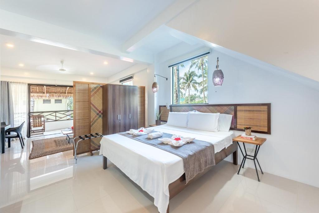 una camera con un grande letto e un balcone di Kalipay Resort Siargao a General Luna