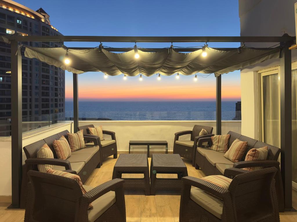 Un balcón con sofás y vistas al océano. en Seaview Rooftop in San Stefano, en Alejandría