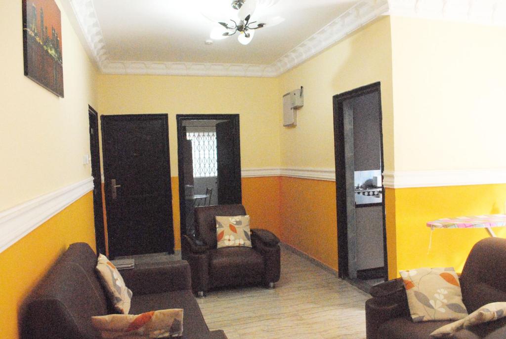 ein Wohnzimmer mit 2 Stühlen und 2 Türen in der Unterkunft Comfort Home in Accra