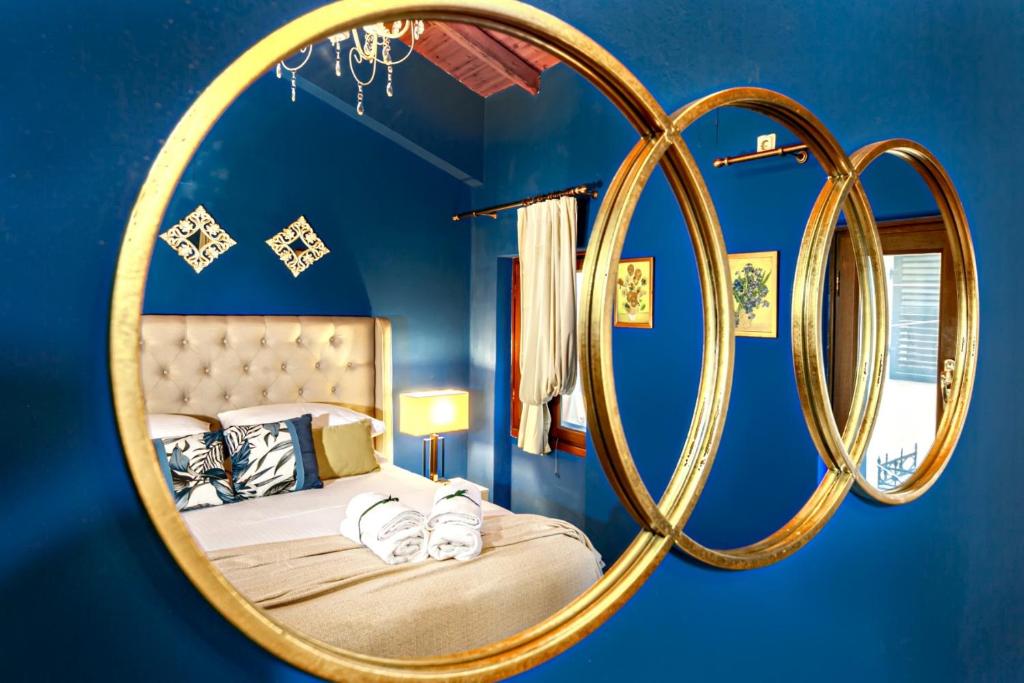 una camera da letto con un letto e un grande specchio d'oro di Via Porta Raimonda (Luxury central detached house) a Città di Corfù