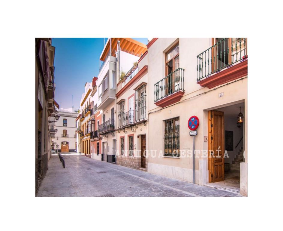 an empty street in a city with buildings at Antigua Cestería in Seville