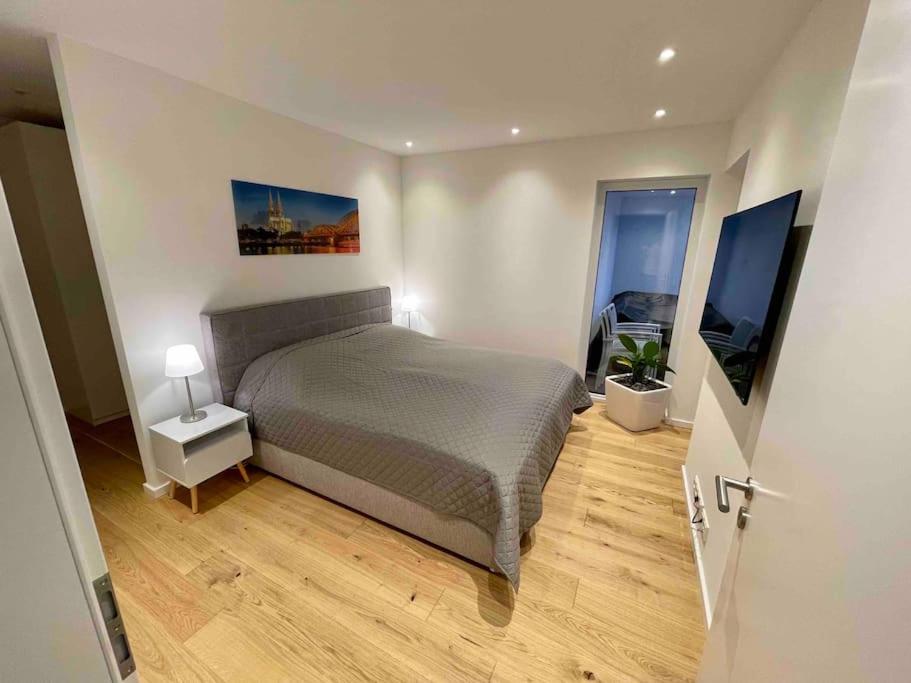 1 dormitorio con 1 cama y TV en Luxuswohnung 95qm in Waldrandlage zwischen Köln und Düsseldorf-Nähe Messe - Lanxessarena - Bayarena en Leverkusen