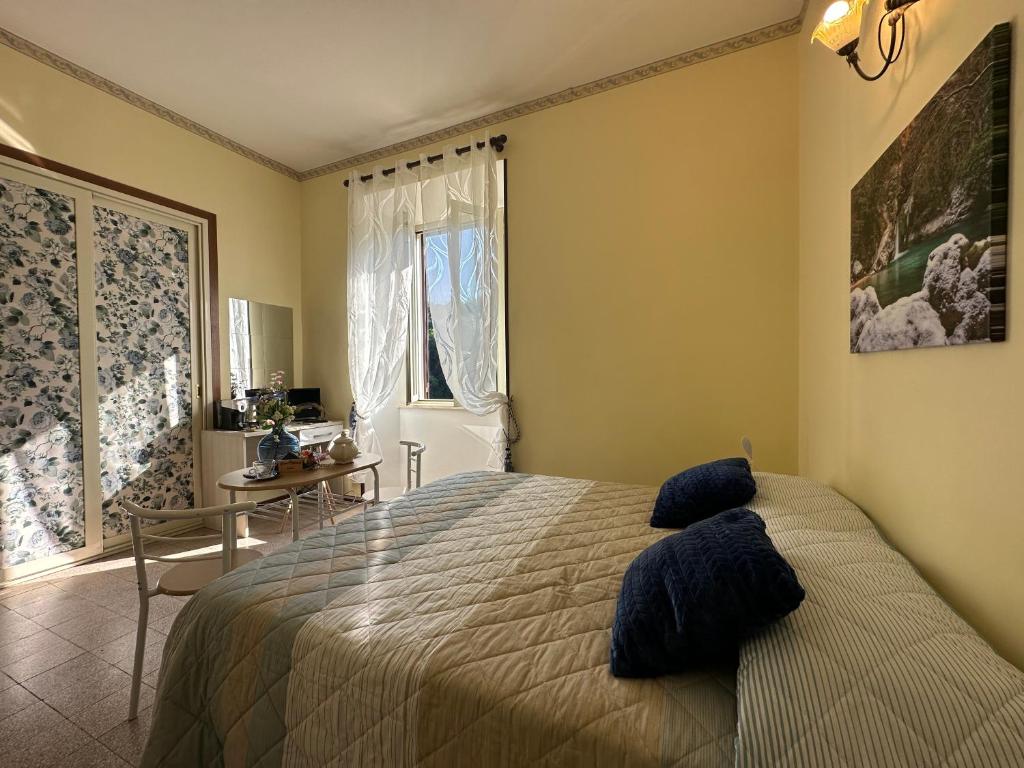 a bedroom with a bed and a desk and a window at Guest House Subiaco LA DOMUS in Subiaco