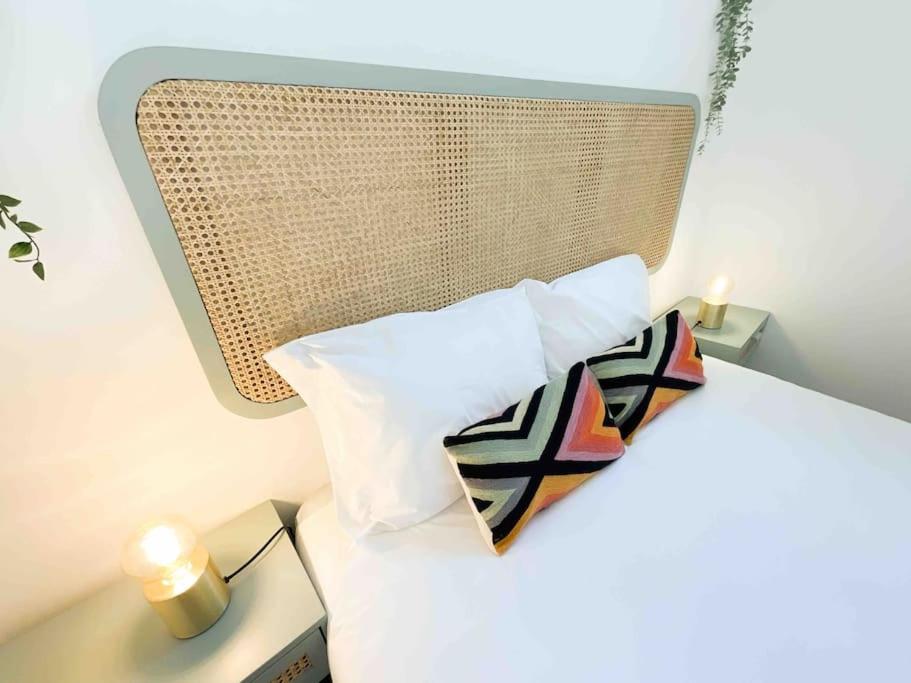 a bed with two pillows and a candle on a table at Beautiful Apartment near Carcavelos Beach in Parede