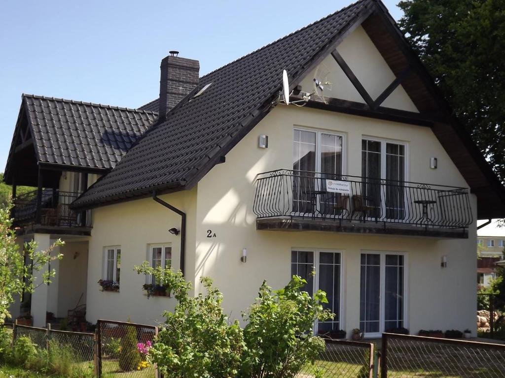 una casa blanca con techo negro en Apartamenty Otylka, en Wisełka