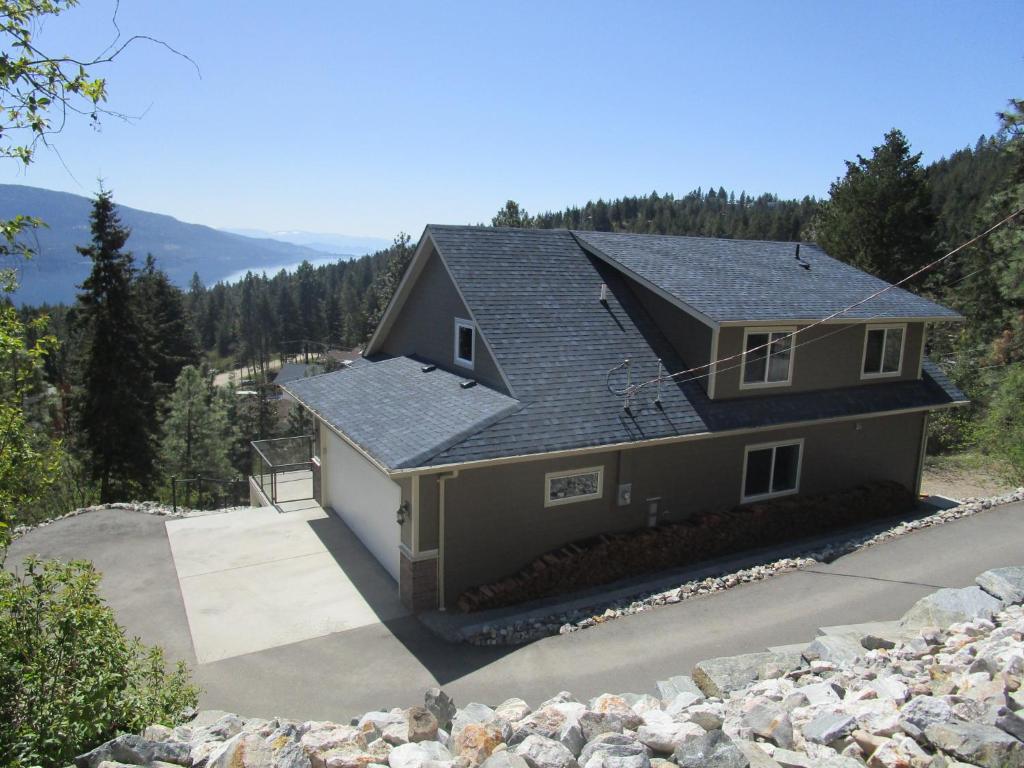 a house with a roof on top of a hill at Okanagan Lake Sunrise BB in Vernon