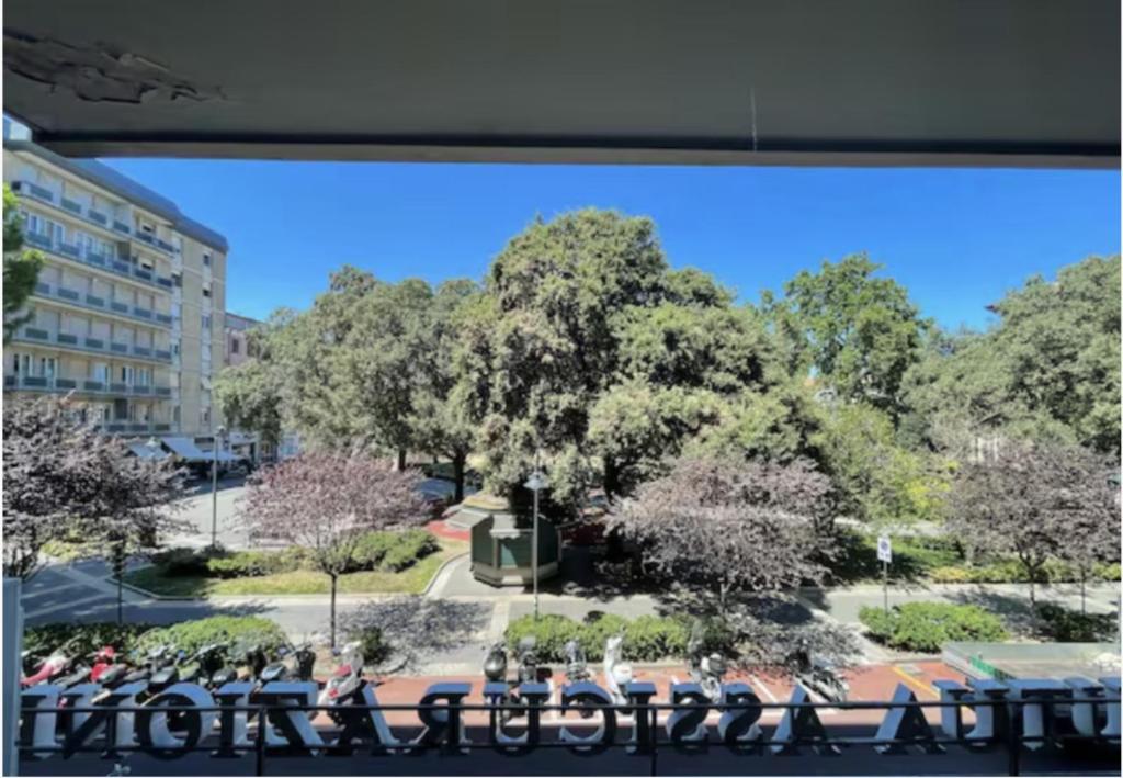 - une vue sur un parc avec des tables et un arbre dans l'établissement Casa Domus del Chirurgo, à Rimini