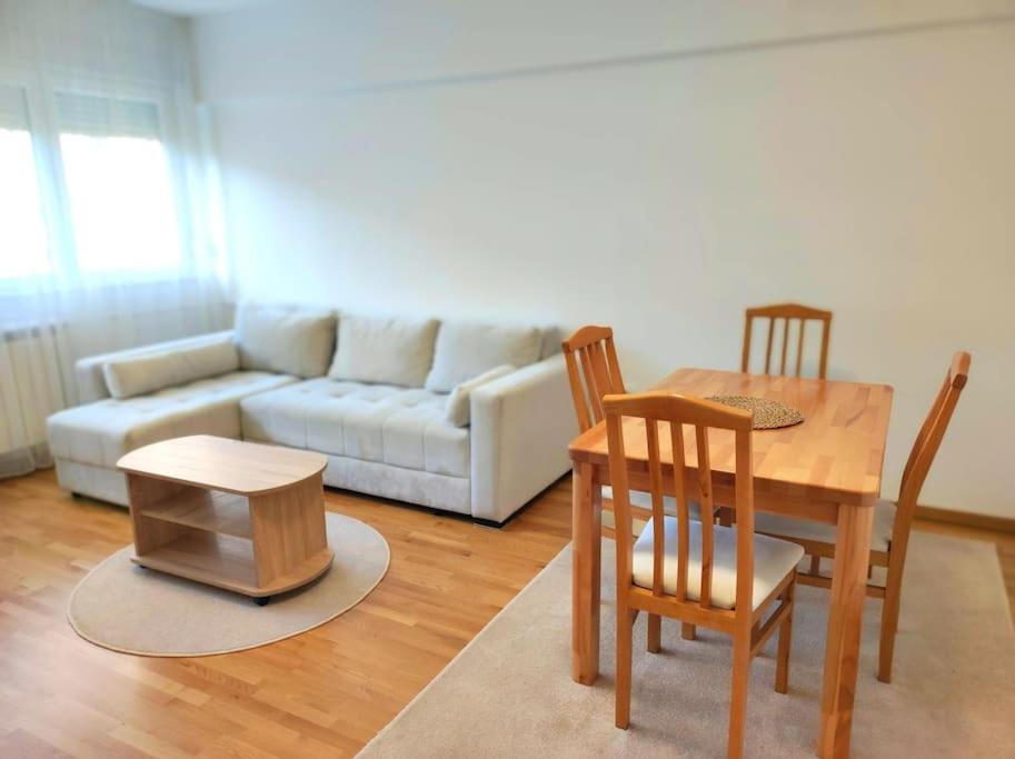 una sala de estar con una mesa y un sofá en Magenta New Belgrade, en Belgrado
