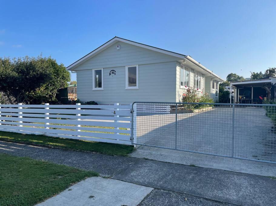 a white fence in front of a house at Turangi Home Family Size in Taupo