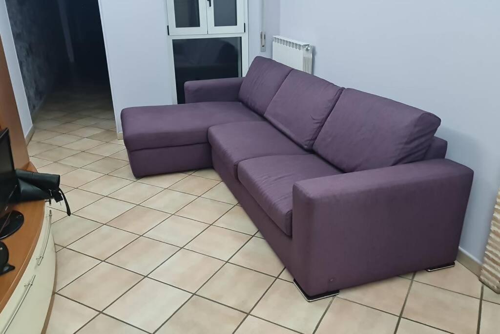 un sofá púrpura en una sala de estar en La Rustica House en Ortona