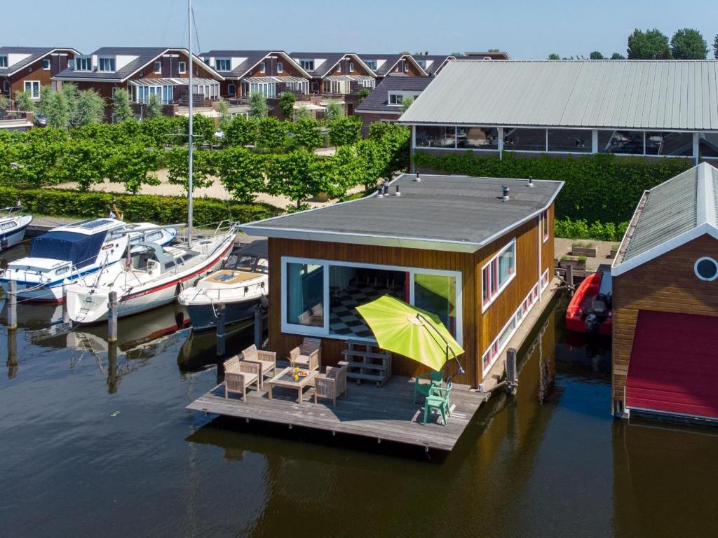 a small house on a dock in the water at Woonark De Woude in Uitgeest