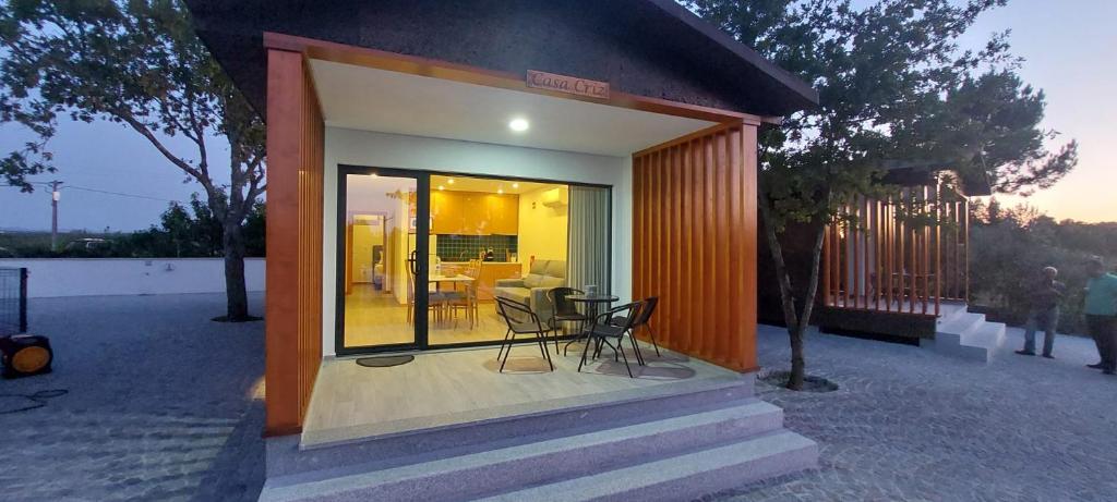 ein kleines Haus mit einer Veranda mit einem Tisch und Stühlen in der Unterkunft School Motorhome Park in Óvoa