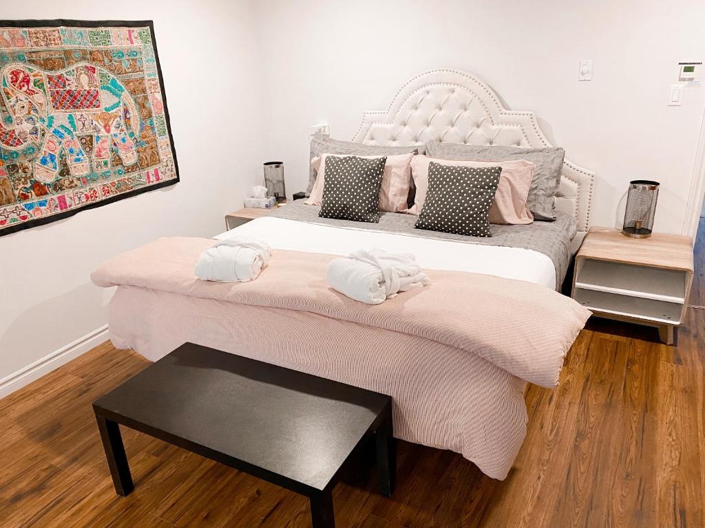 um quarto com uma cama grande e almofadas cor-de-rosa em OCEAN BAY VIEW Luxury Guesthouse em Musquodoboit Harbour