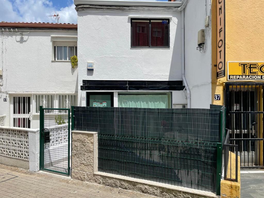 a building with a green gate in front of a building at Pontevedra Centro adosado in Pontevedra