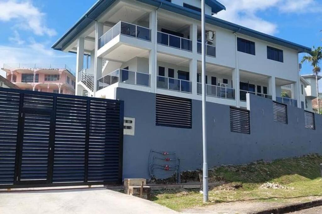 a white house with a gate in front of it at Stunning Two-Bedroom: Perfect Home Away from Home in Suva