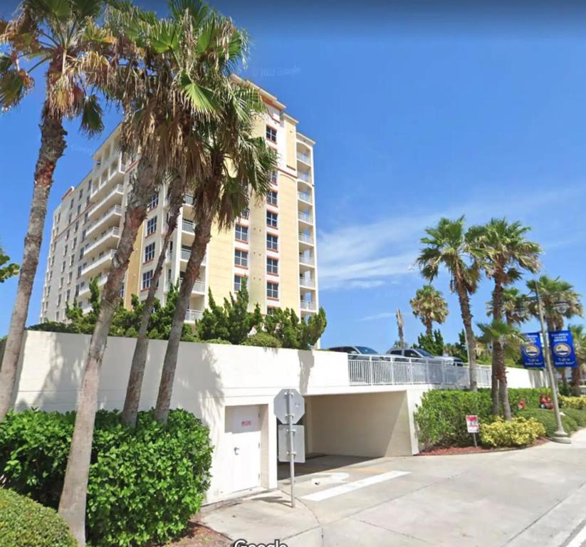 Opus Condominiums في Daytona Beach Shores: مبنى فيه نخيل قدام شارع