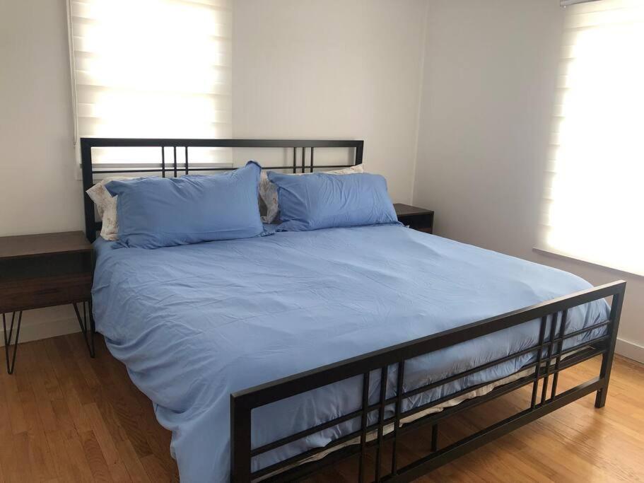 1 dormitorio con 1 cama grande con almohadas azules en Relax & Recharge At The Sea, en Long Branch