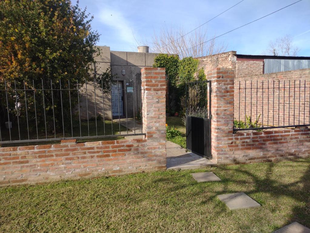 een bakstenen gebouw met een hek en een hek bij La Casa de Ana in San Antonio de Areco
