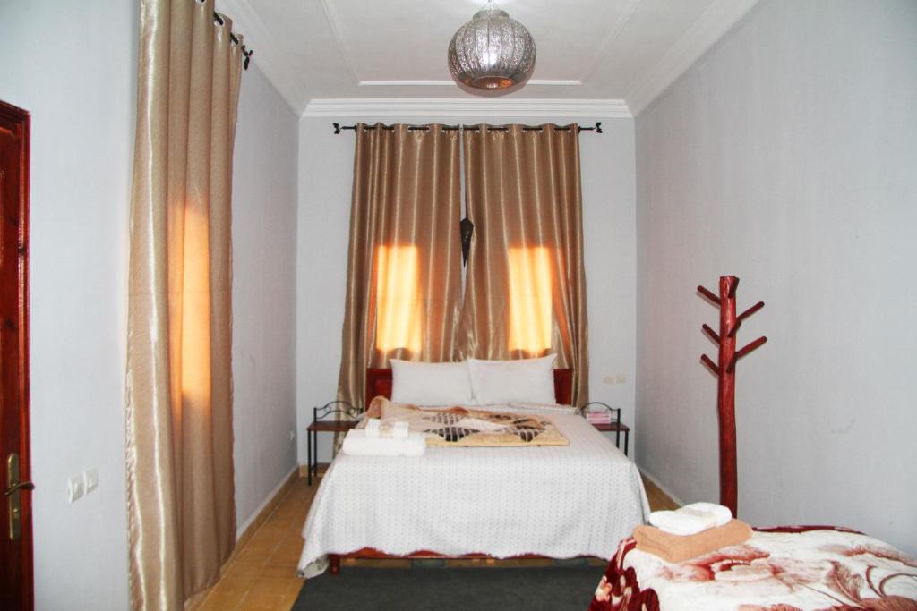 a bedroom with a bed and a window at Riad Ouinz in Aït Ben Haddou