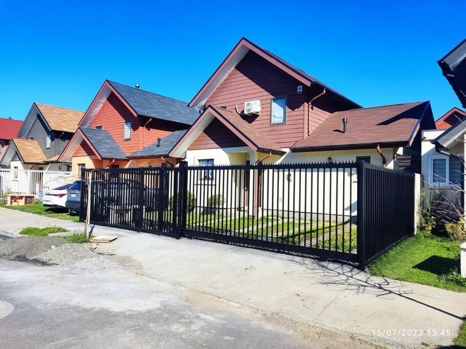 una cerca negra frente a una fila de casas en Casa Amoblada Santa Sofia, en Concepción