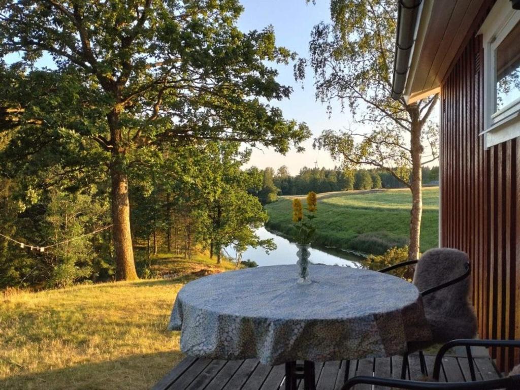 een tafel op een veranda met uitzicht op een rivier bij 6 person holiday home in MELLERUD-By Traum in Brålanda