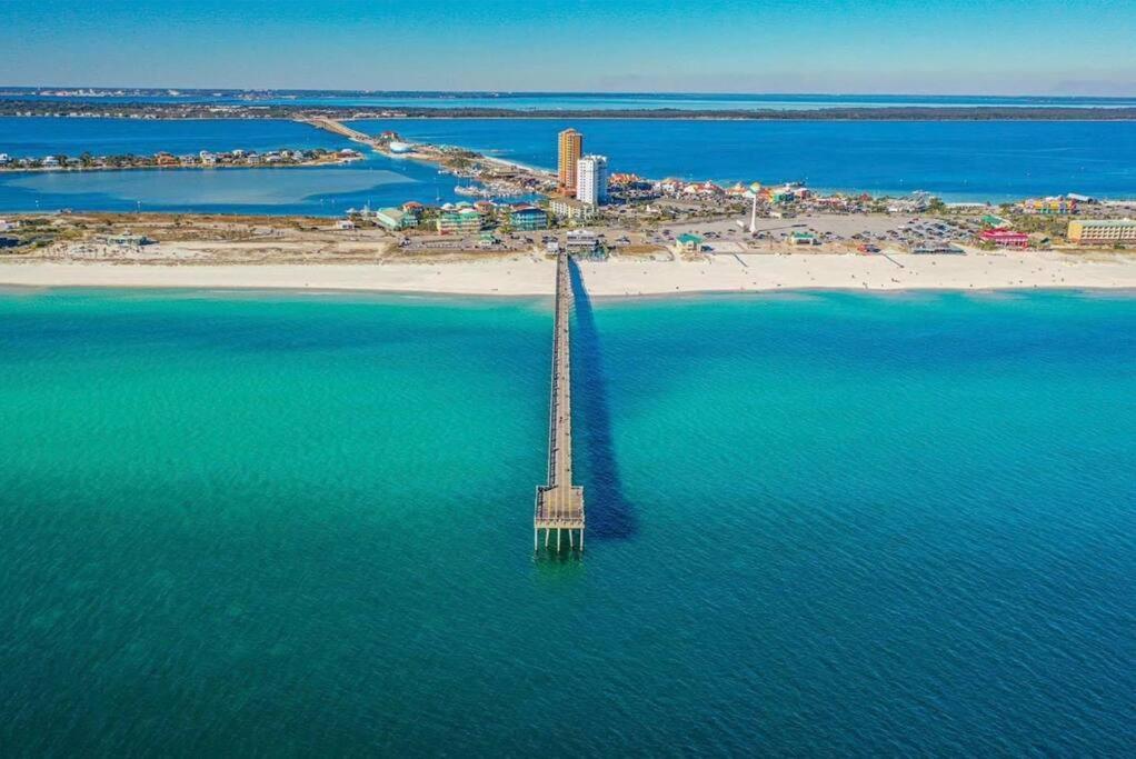 an aerial view of a pier in the water next to a beach at Coral Sky in Pensacola