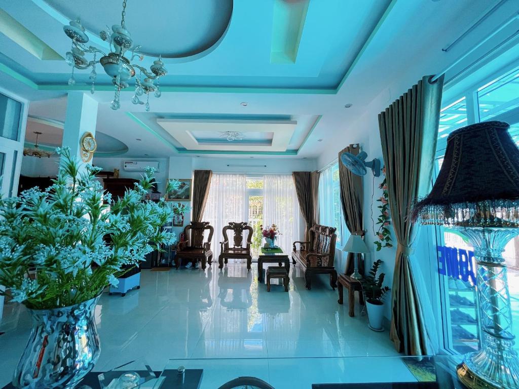 een woonkamer met stoelen en een blauw plafond bij Mai An Homestay in Thôn Trường Giang