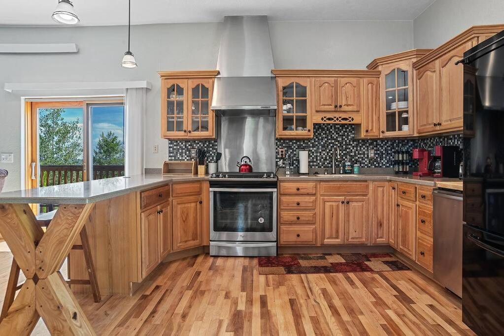 a kitchen with wooden cabinets and stainless steel appliances at Coppertop- Firepit-Skyline Views in Rapid City